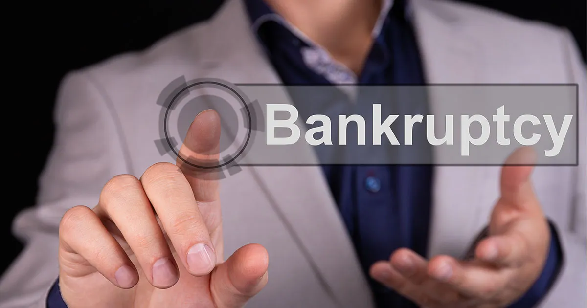A person pressing a digital button labeled "Bankruptcy".