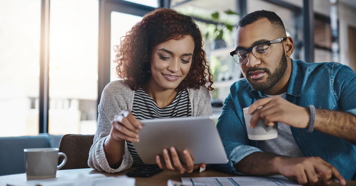 A couple looking at a tablet together at a table