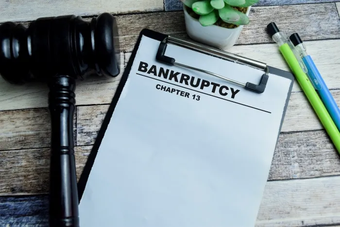 A clipboard labeled "BANKRUPTCY CHAPTER 13" next to a gavel and pens.