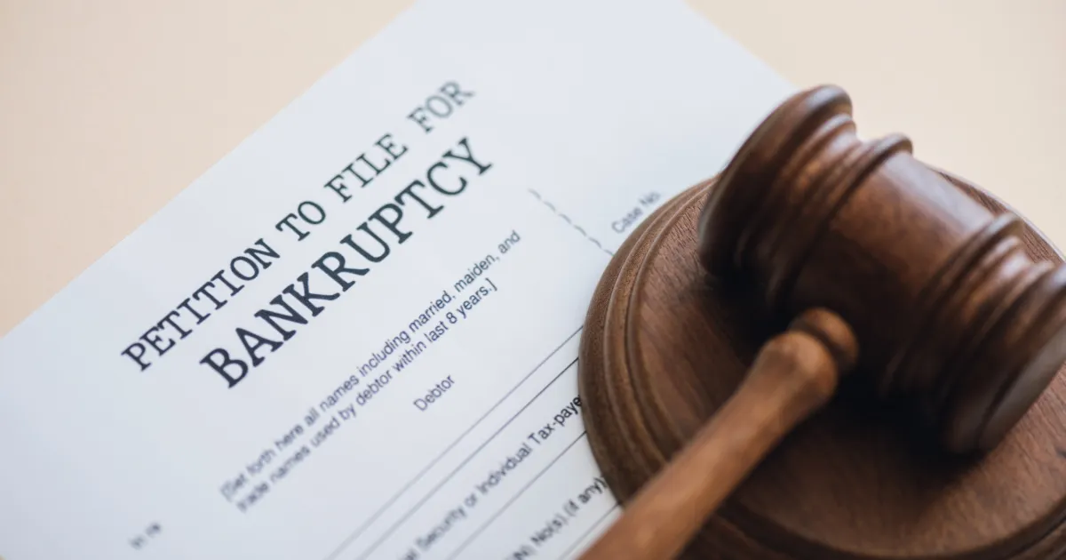 A "Petition to File for Bankruptcy" document next to a wooden gavel.