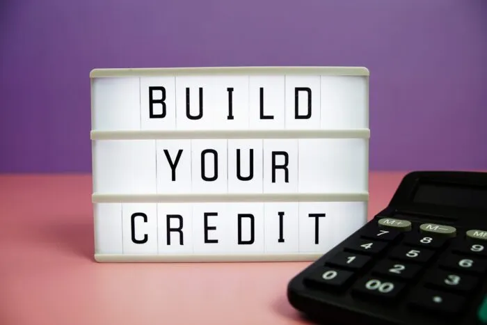 A lightbox displaying the phrase "BUILD YOUR CREDIT" next to a calculator.